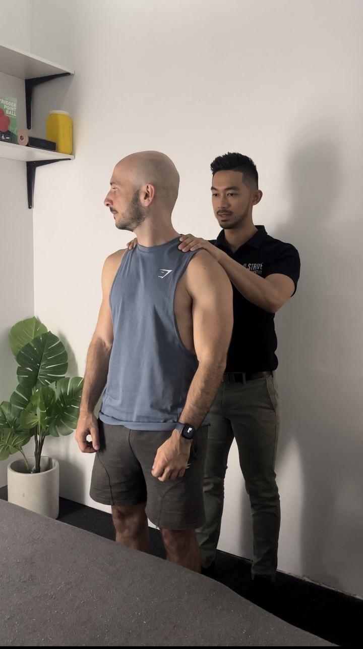 Joshua Milanes assessing a patient's posture at Strive Osteopathy